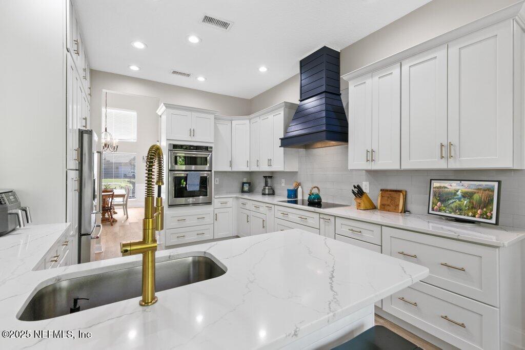 2676 Country Side Drive Fleming Island, FL 32003 - Photo 25 of 125 a kitchen with stainless steel appliances granite countertop a sink and a refrigerator