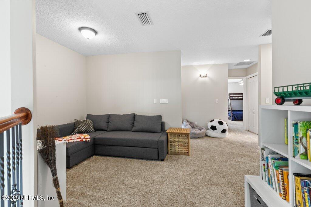2676 Country Side Drive Fleming Island, FL 32003 - Photo 50 of 125 a living room with furniture and a book shelf