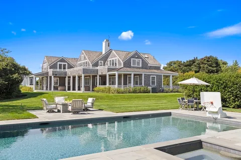 a front view of a house with swimming pool having outdoor seating