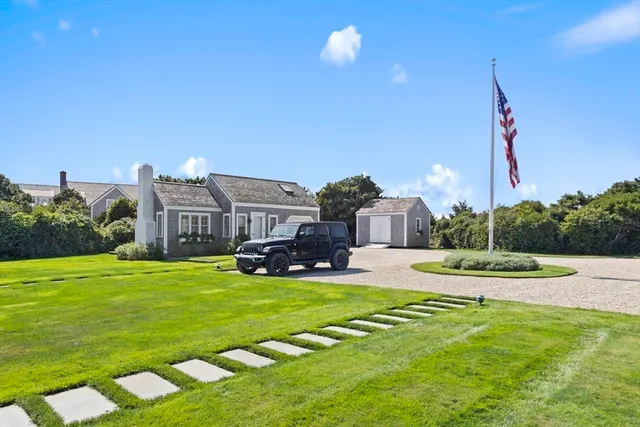 a view of a house with a big yard and potted plants
