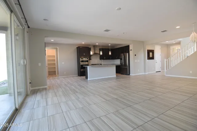 a kitchen with stainless steel appliances kitchen island granite countertop a refrigerator and a sink