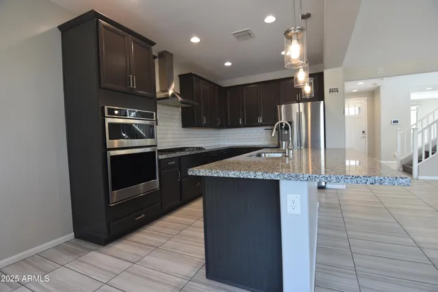 a kitchen with stainless steel appliances wooden cabinets a sink and a stove