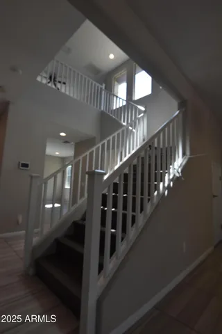 a view of an empty room with wooden floor and a ceiling fan