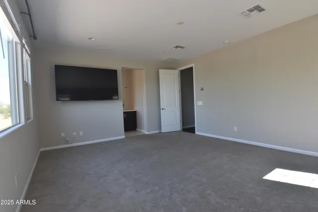 an empty room with windows and television