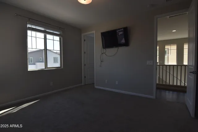 a view of an empty room with a flat screen tv and a window