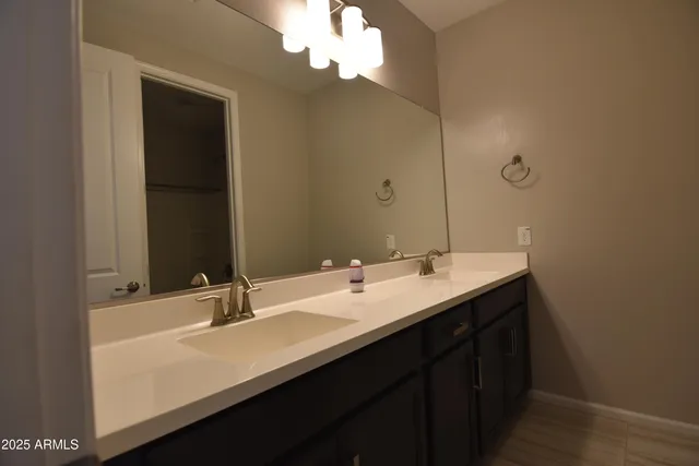 a bathroom with a granite countertop sink a bathtub a mirror and window