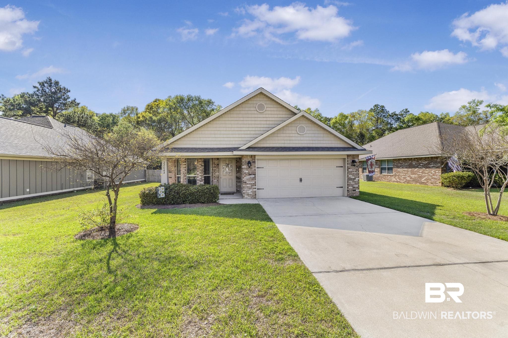 22043 Garland Loop Silverhill, AL 36576 - Photo 4 of 41 Craftsman house featuring a front lawn, concrete driveway, brick siding, an attached garage, and a shingled roof