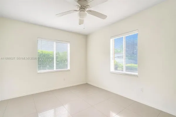 an empty room with a window and a ceiling fan