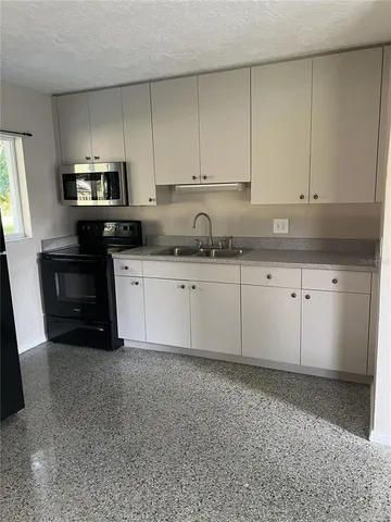 a kitchen with granite countertop white cabinets and stainless steel appliances