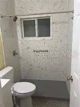 a bathroom with a toilet and a shower