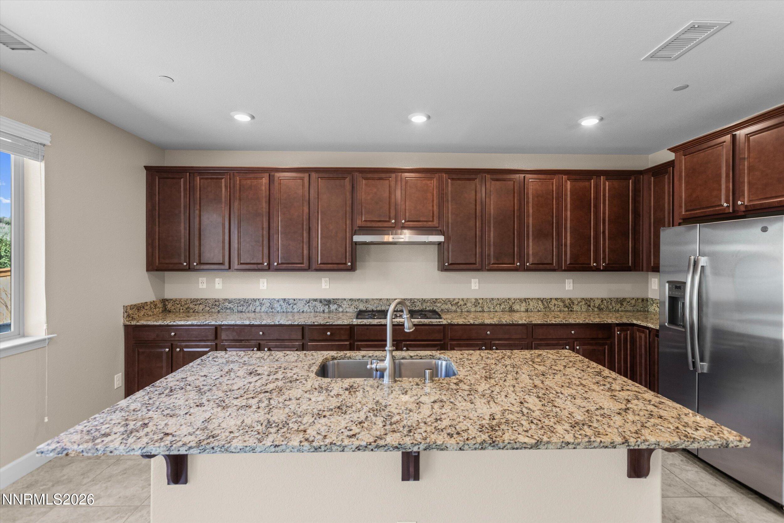 1725 Verdi Vista Court Reno, NV 89523 - Photo 10 of 37 a kitchen with kitchen island granite countertop a sink and a refrigerator