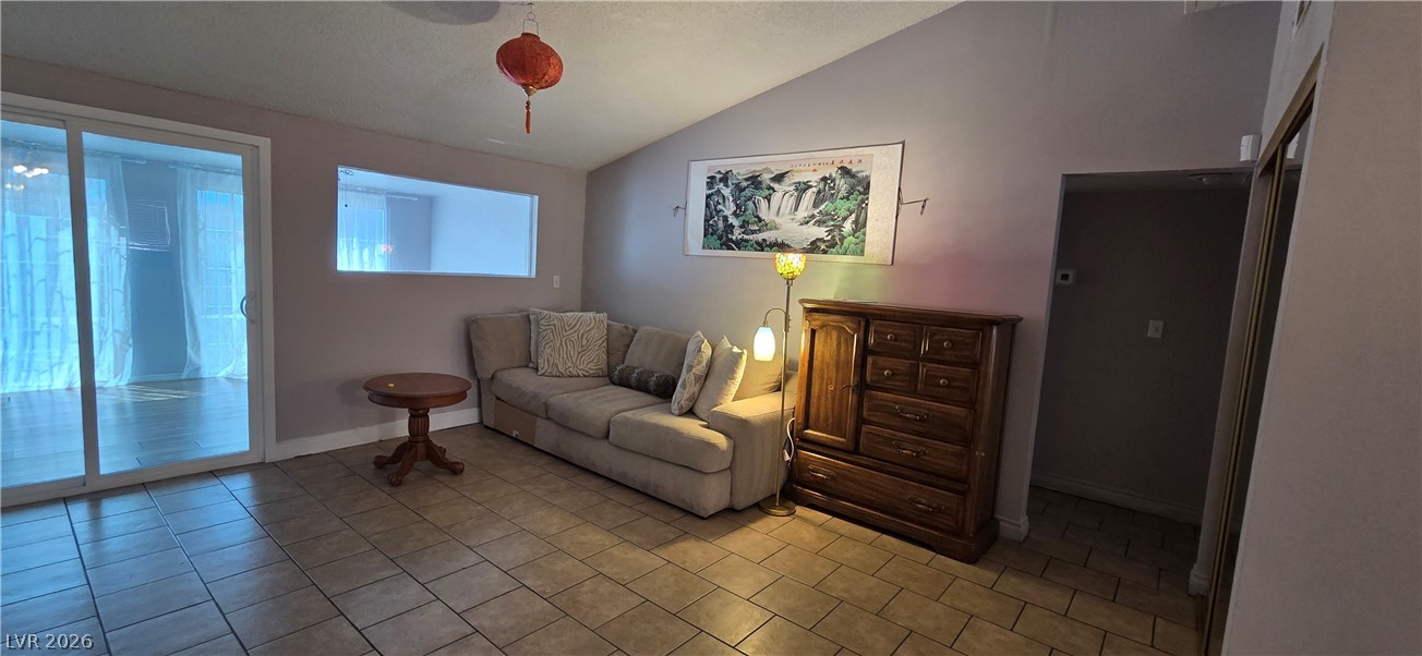 Vaulted ceilings and tile flooring create an open atmosphere in this living area.