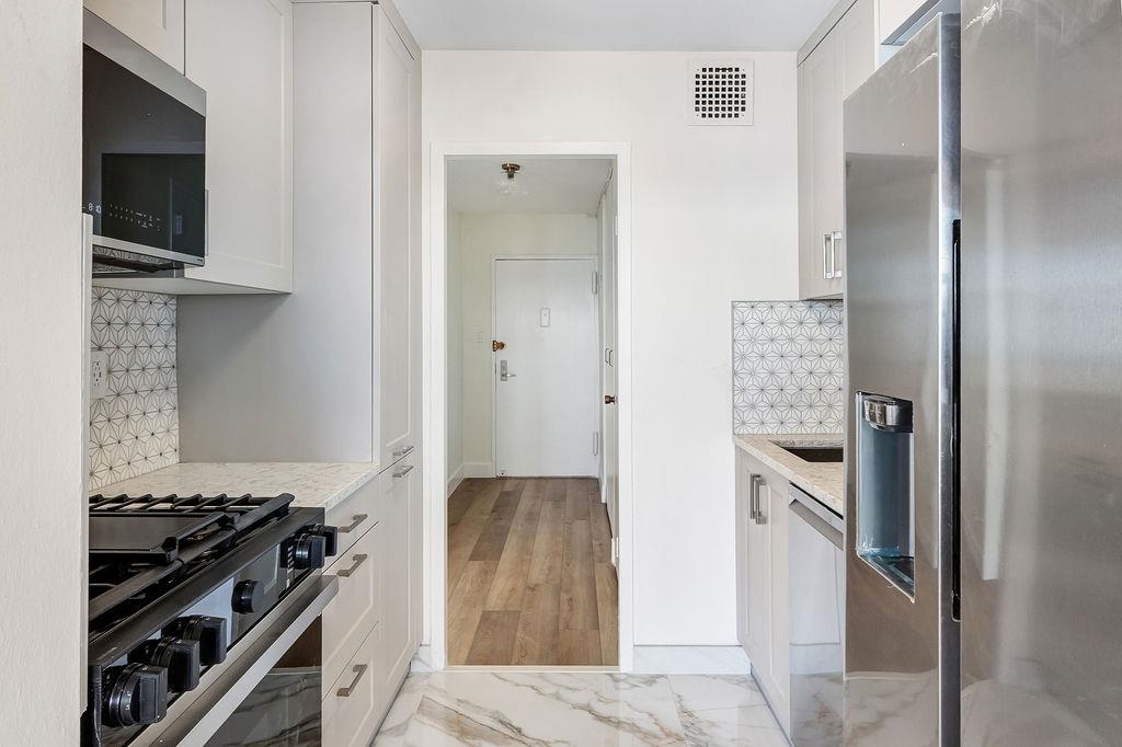 6040 Boulevard East, Unit 22F West New York, NJ 07093 - Photo 11 of 44 a kitchen with stainless steel appliances granite countertop a refrigerator and a stove