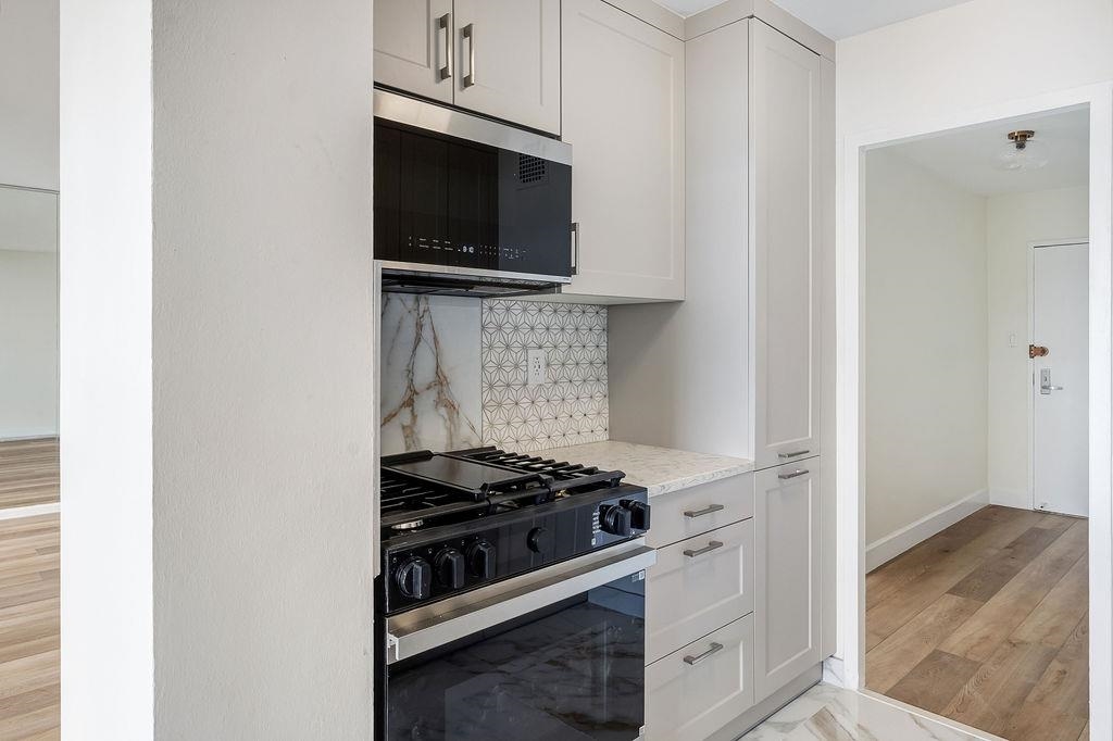 6040 Boulevard East, Unit 22F West New York, NJ 07093 - Photo 14 of 44 a kitchen with stainless steel appliances a stove and a microwave