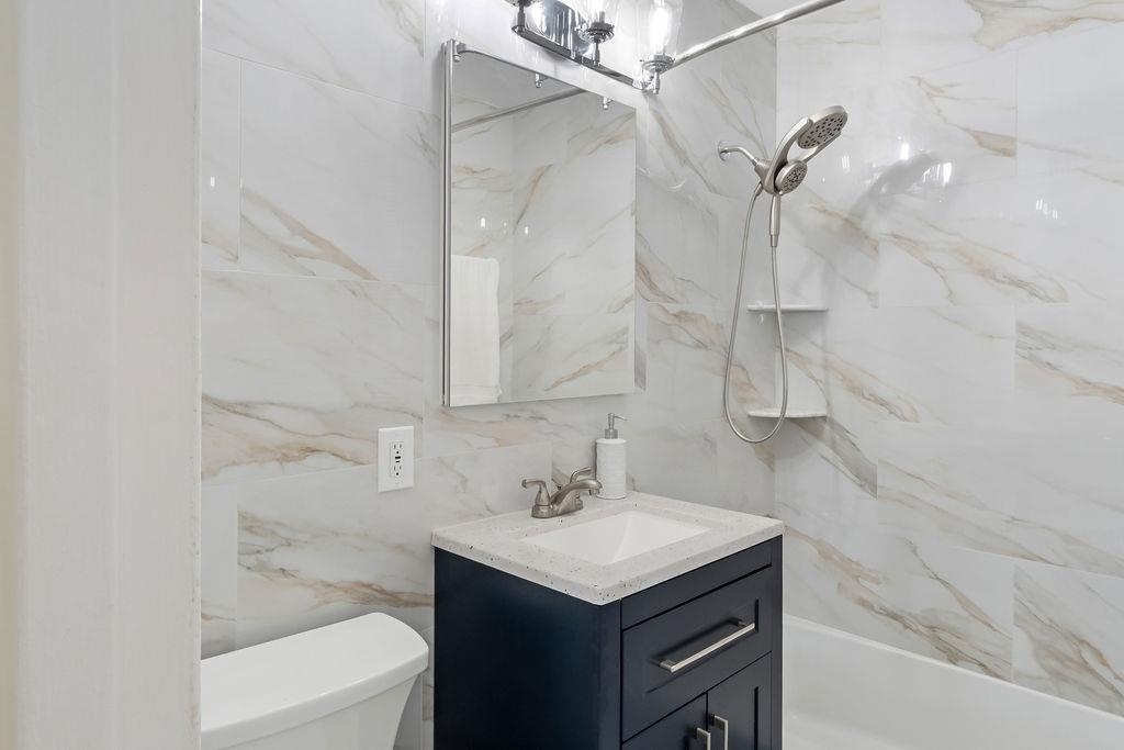 6040 Boulevard East, Unit 22F West New York, NJ 07093 - Photo 16 of 44 a bathroom with a granite countertop sink a toilet and shower