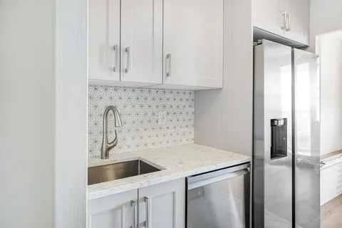 a kitchen with stainless steel appliances a refrigerator sink and cabinets