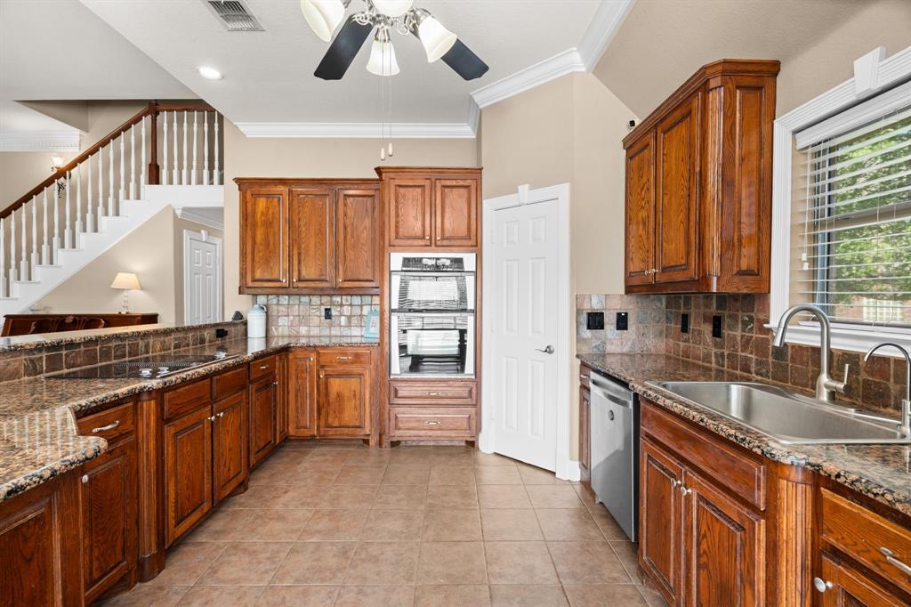 112 Waterfall Court Azle, TX 76020 - Photo 12 of 40 a kitchen with stainless steel appliances granite countertop a sink and dishwasher a stove top oven with wooden floor