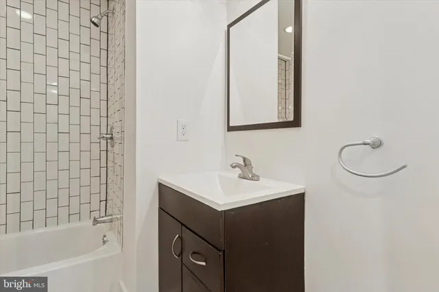 a bathroom with a sink vanity tub and a mirror