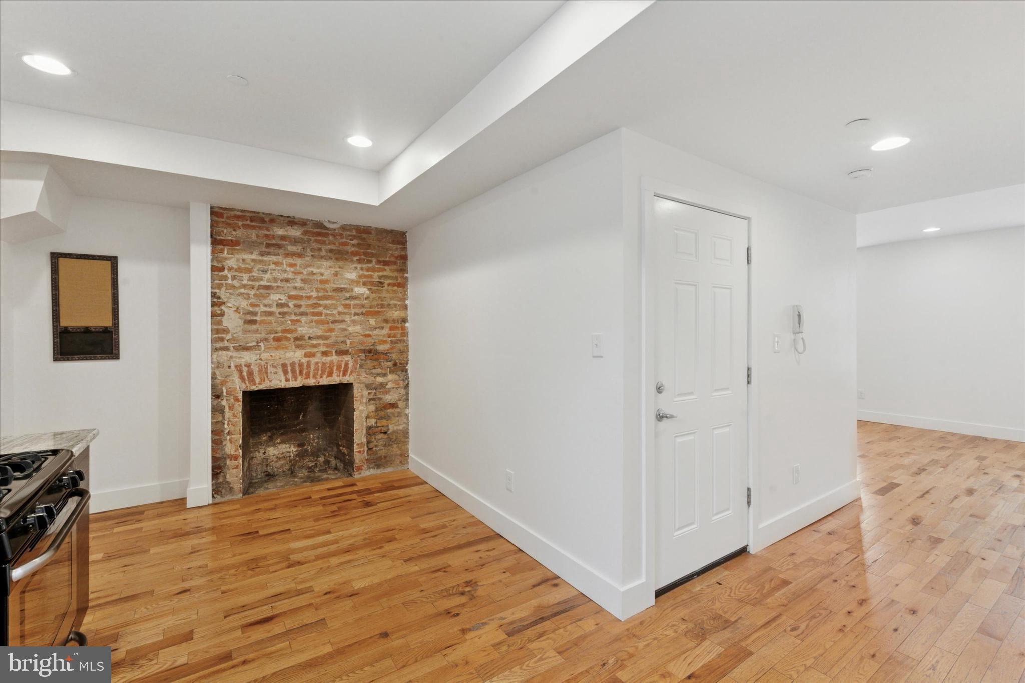 1014 North 4th Street, Unit 2 Philadelphia, PA 19123 - Photo 7 of 16 a view of empty room with wooden floor and fireplace