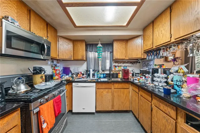 a kitchen with stainless steel appliances granite countertop a sink stove and cabinets