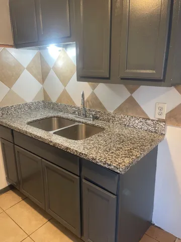 a kitchen with kitchen island granite countertop a sink and granite counter tops