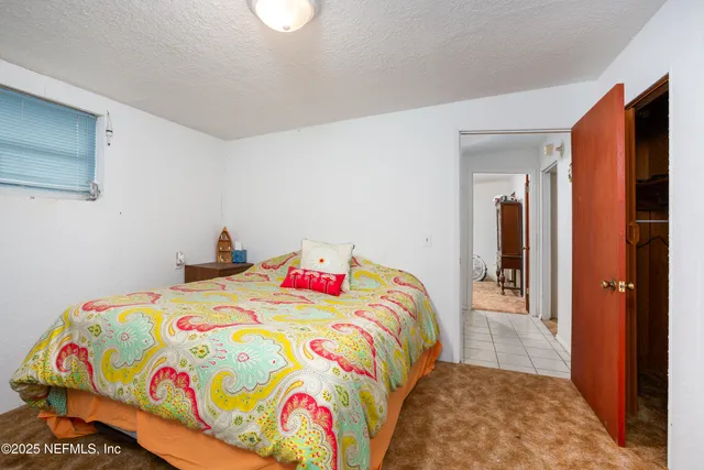 a bedroom with a bed and a painting on the wall