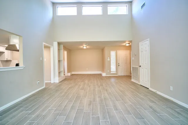 a view of a room with wooden floor and windows