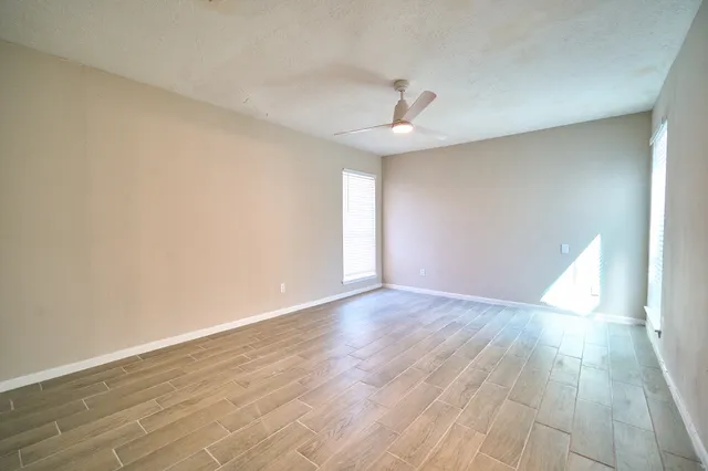 wooden floor in an empty room with a window