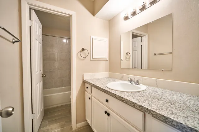 a bathroom with a granite countertop sink shower and a mirror