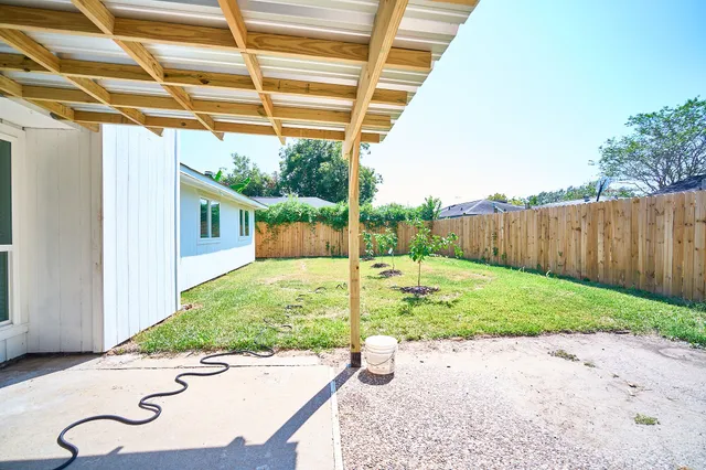 a view of a backyard with table and chairs and wooden fence