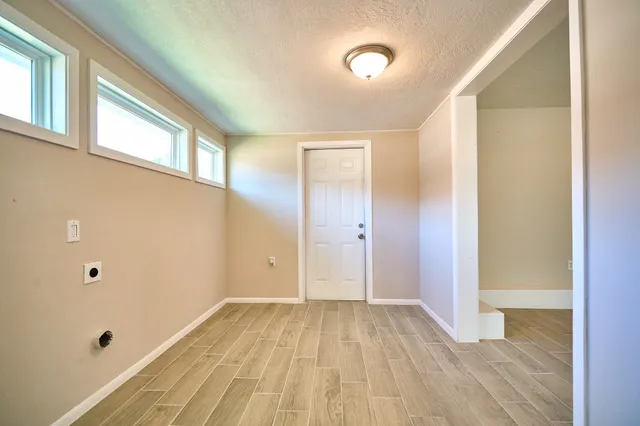 a view of a room with wooden floor and windows