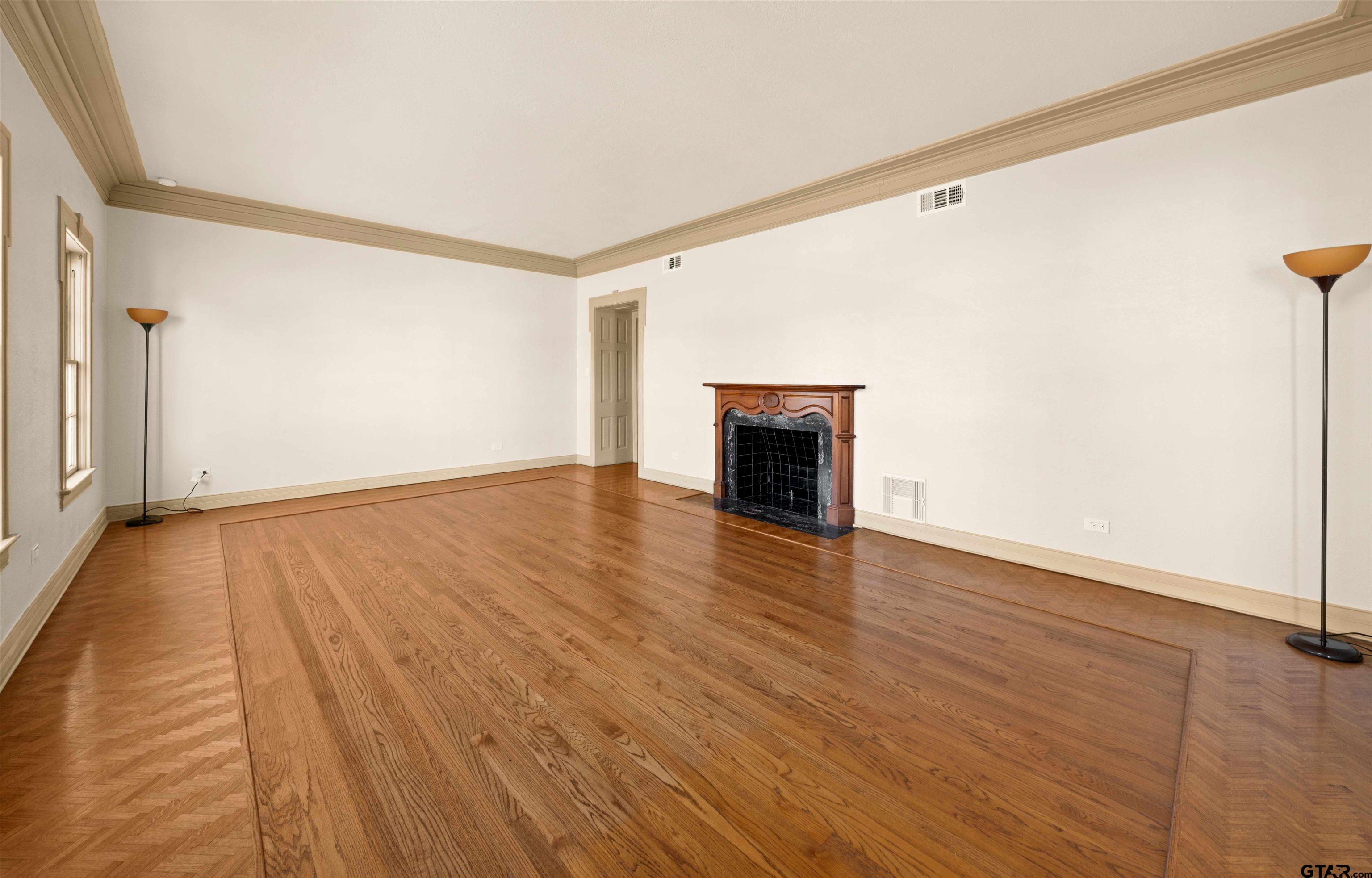 213 East 2nd Street Tyler, TX 75701 - Photo 4 of 48 a view of an empty room with wooden floor and a window