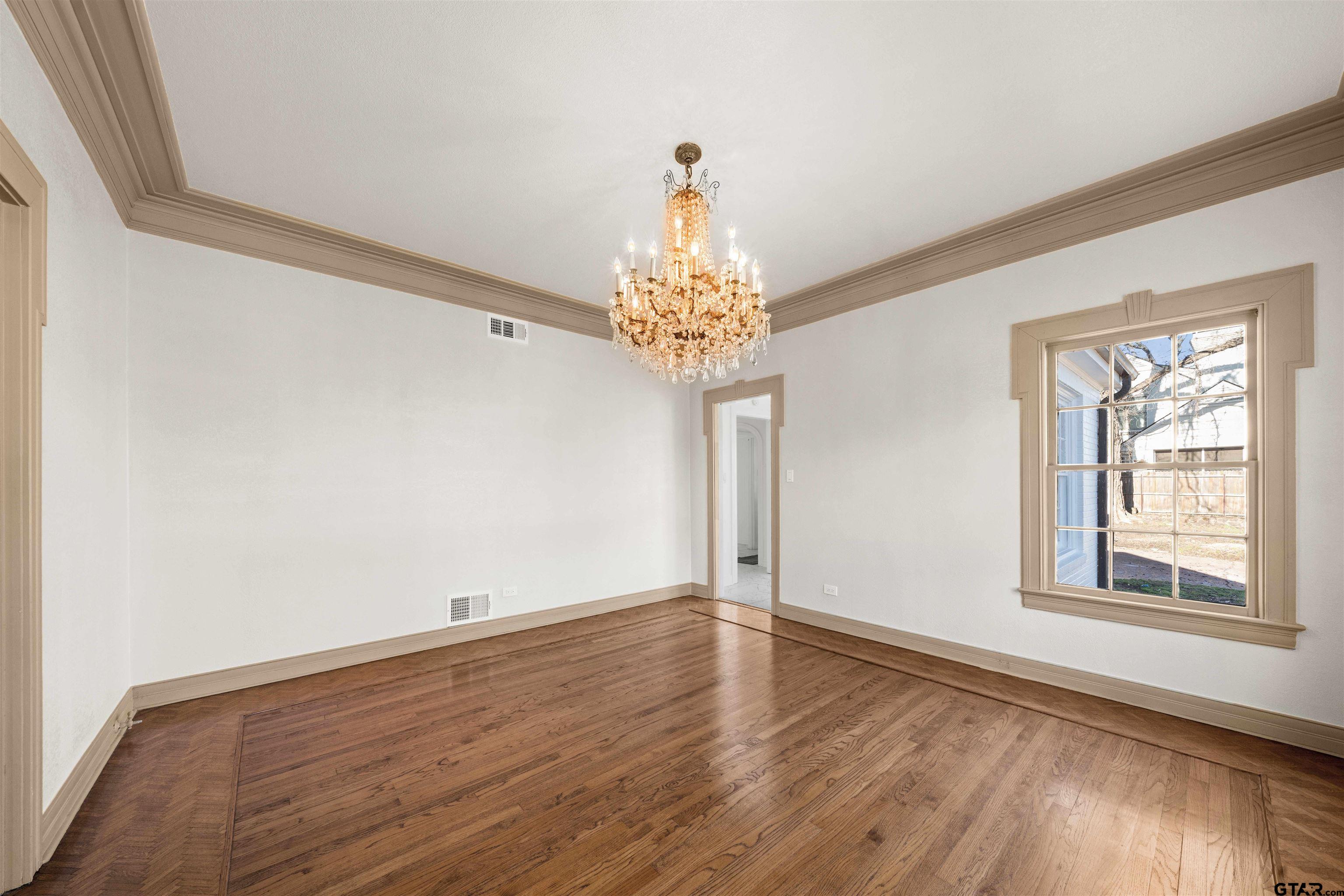 213 East 2nd Street Tyler, TX 75701 - Photo 7 of 48 a view of an empty room with wooden floor and a window