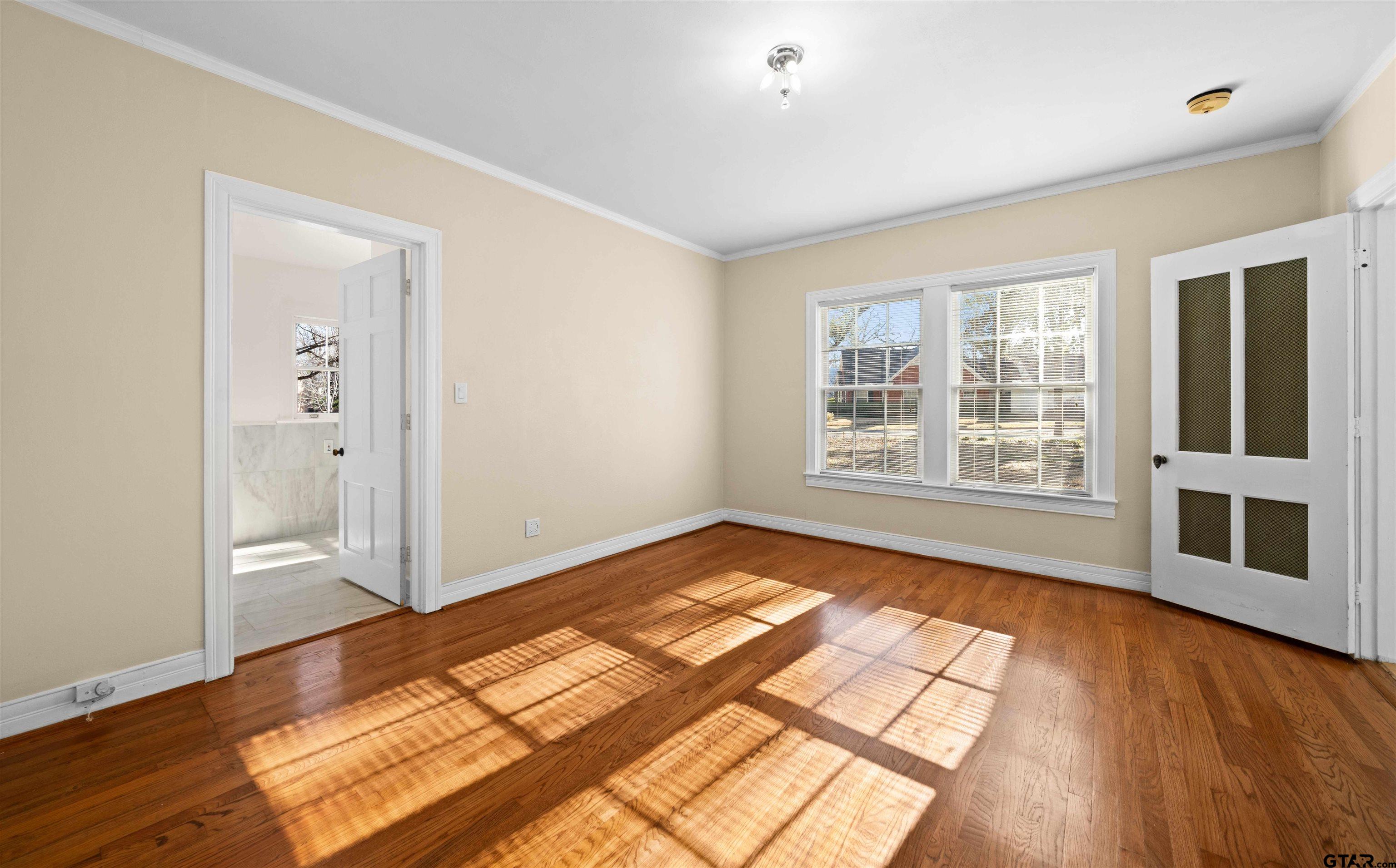 213 East 2nd Street Tyler, TX 75701 - Photo 9 of 48 a view of an empty room with wooden floor and a window