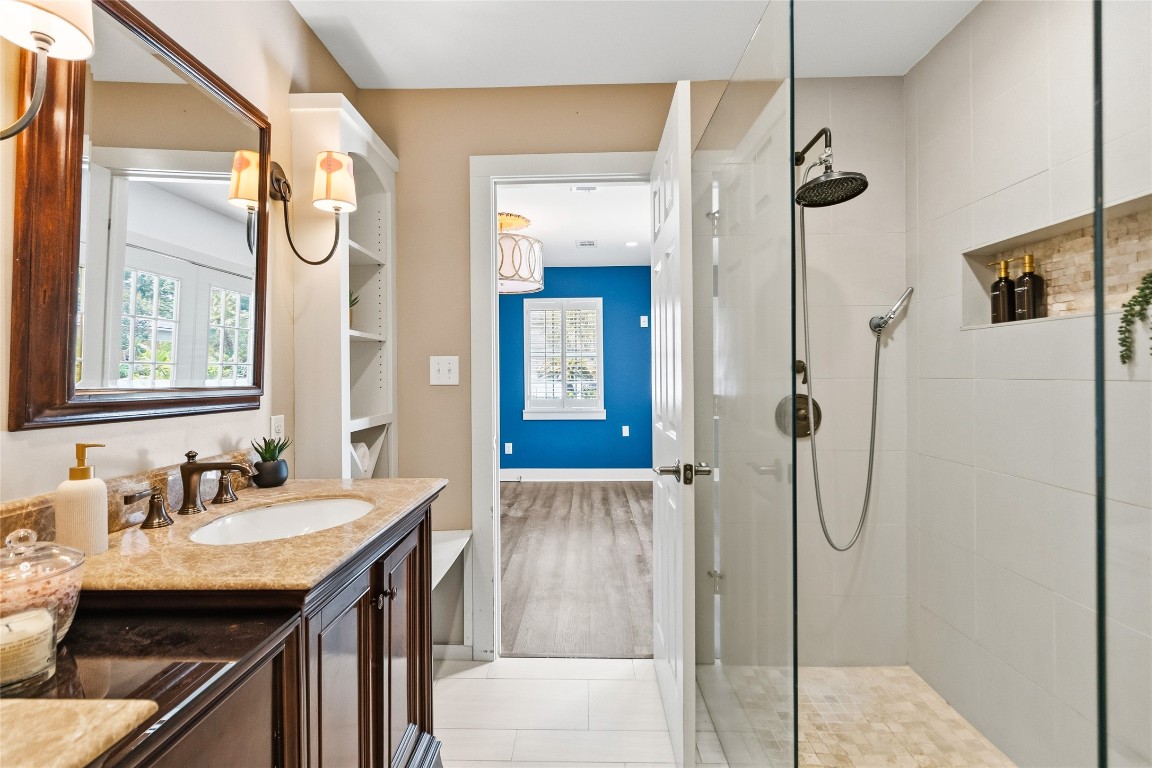 1914 Peppermill Road Houston, TX 77080 - Photo 23 of 43 Warm tones and classic finishes give this bathroom a comfortable feel, while the glass-enclosed shower adds a clean, updated touch.