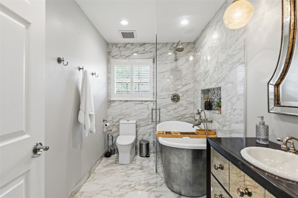 1914 Peppermill Road Houston, TX 77080 - Photo 25 of 43 This bathroom feels like your own private escape, with dramatic marble-look finishes, a freestanding soaking tub, and a sleek walk-in shower that turns daily routines into something elevated.