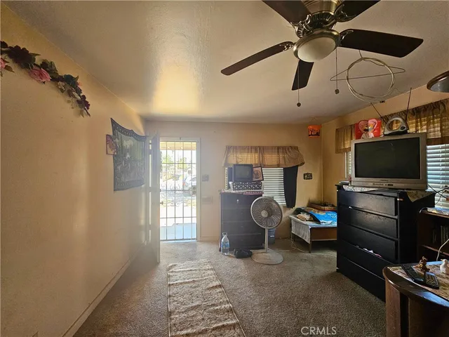 a living room with furniture a flat screen tv and a window