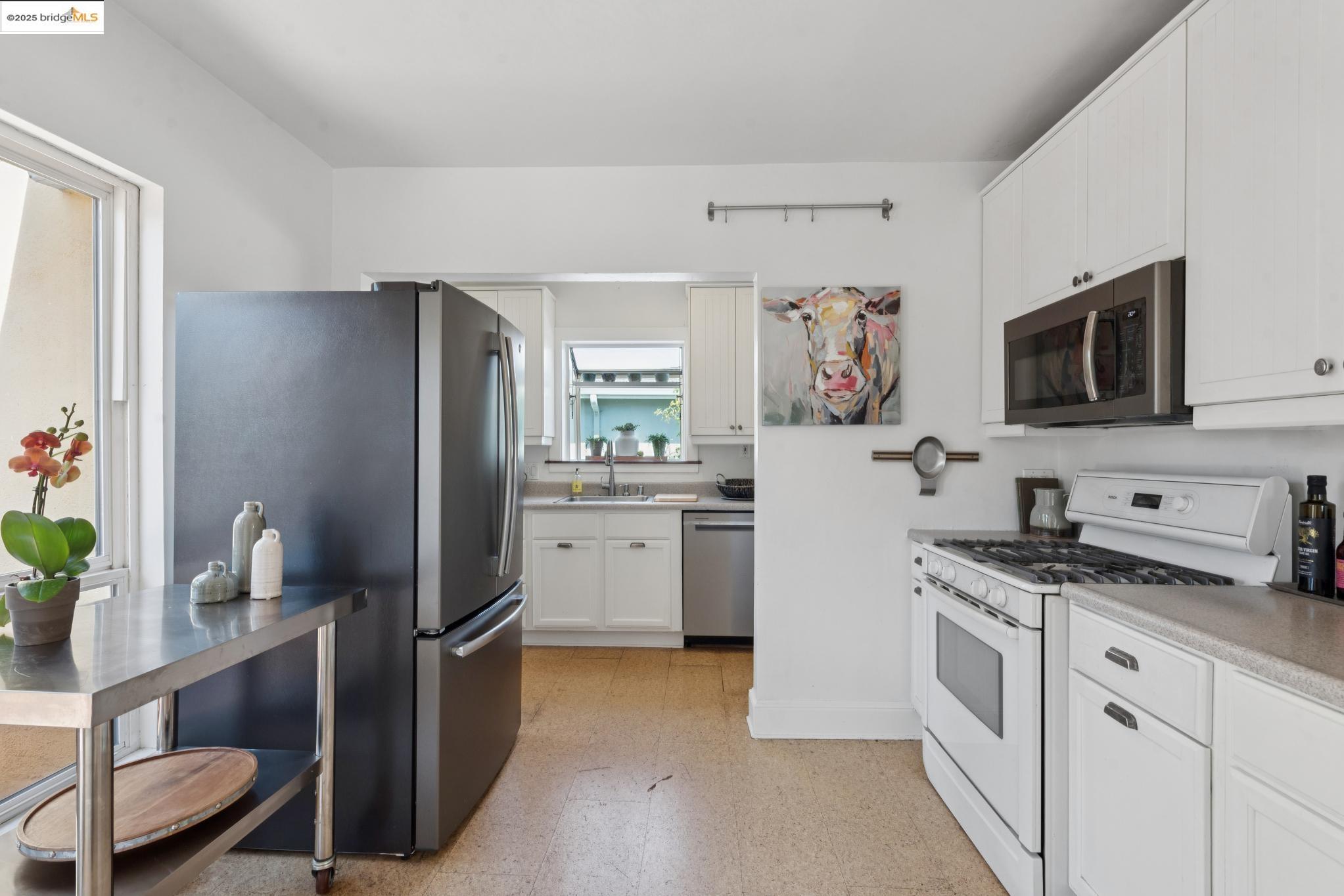 2721 Best Avenue Oakland, CA 94619 - Photo 12 of 28 Kitchen with appliances with stainless steel finishes, light flooring, light countertops, and white cabinetry
