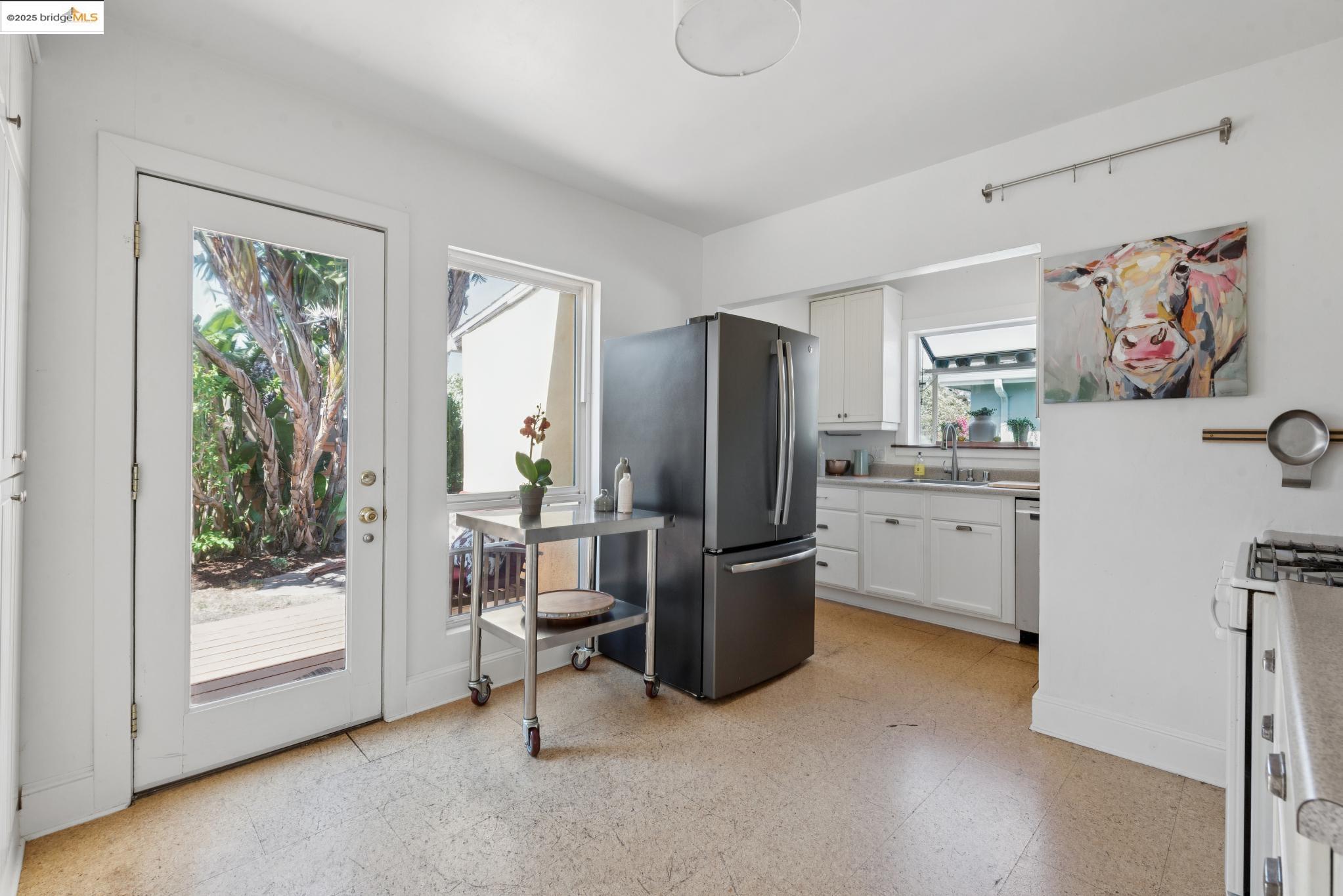 2721 Best Avenue Oakland, CA 94619 - Photo 10 of 28 Kitchen with light flooring, light countertops, white cabinets, freestanding refrigerator, and white range with gas cooktop