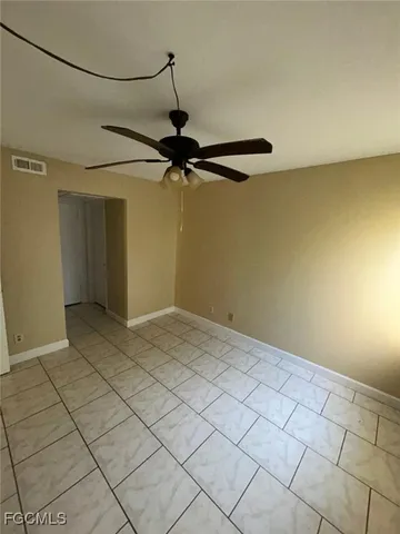a view of a room with a hanging light and carpet