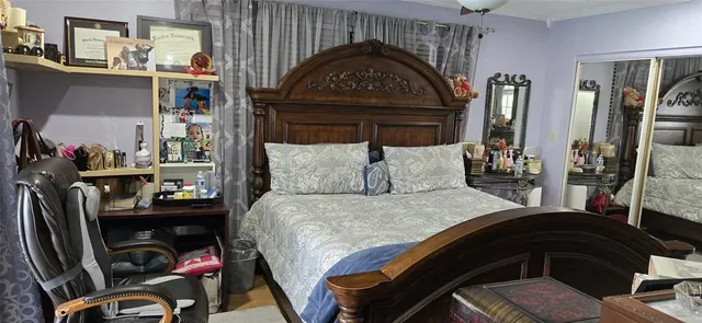 a bedroom with a bed closet and a mirror