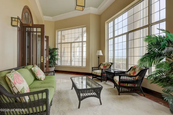 a living room with furniture and floor to ceiling windows