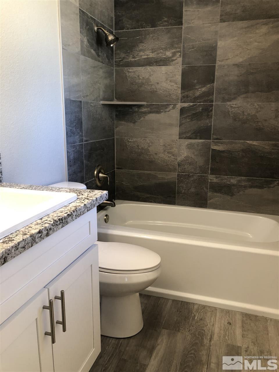 3865 Snipe Drive Reno, NV 89508 - Photo 11 of 19 a bathroom with a granite countertop bathtub shower sink and toilet