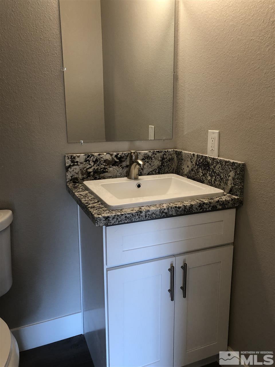 3865 Snipe Drive Reno, NV 89508 - Photo 16 of 19 a bathroom with a granite countertop sink and a mirror