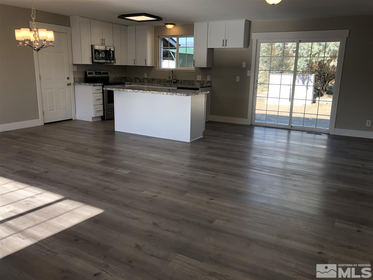 3865 Snipe Drive Reno, NV 89508 - Photo 6 of 19 a kitchen with stainless steel appliances granite countertop a refrigerator a sink a stove a microwave and wooden floor