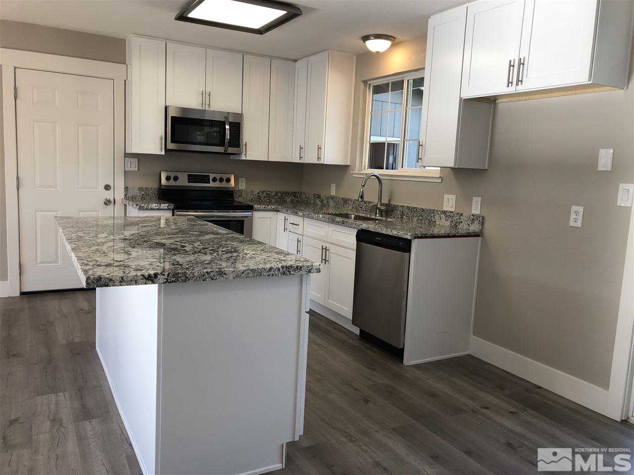 3865 Snipe Drive Reno, NV 89508 - Photo 8 of 19 a kitchen with stainless steel appliances granite countertop a sink stove microwave and refrigerator