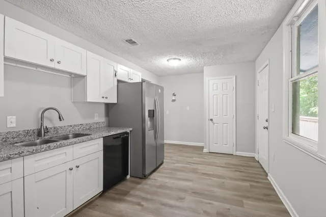 a view of a kitchen with white cabinets