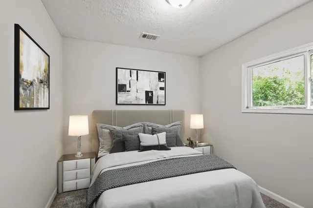 a bedroom with a bed and a painting on the wall