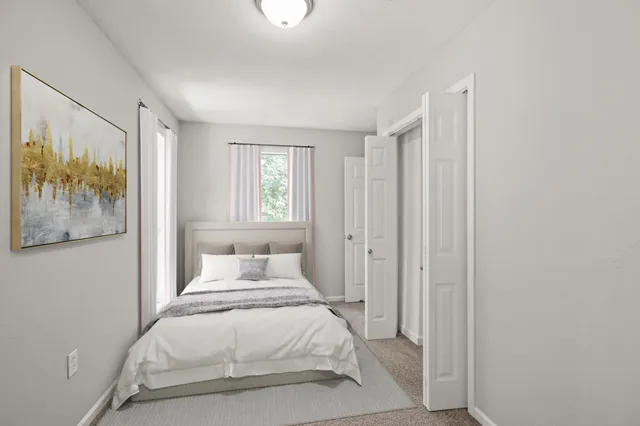 a bedroom with a bed and a painting on the wall