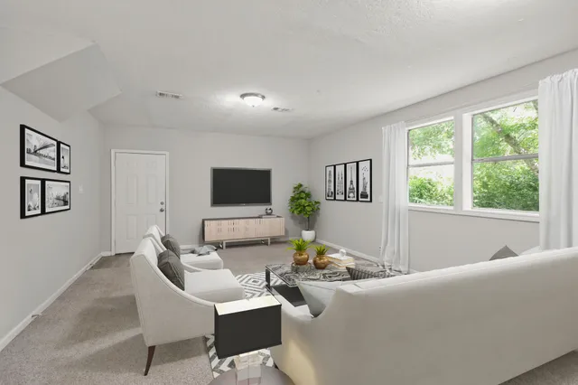 a living room with furniture a flat screen tv and a large window